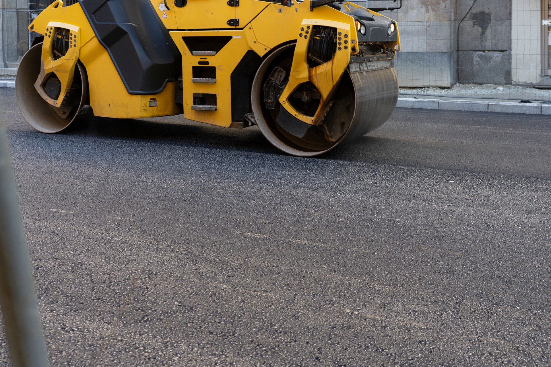Asphalt paving machine compacting asphalt on a new road
